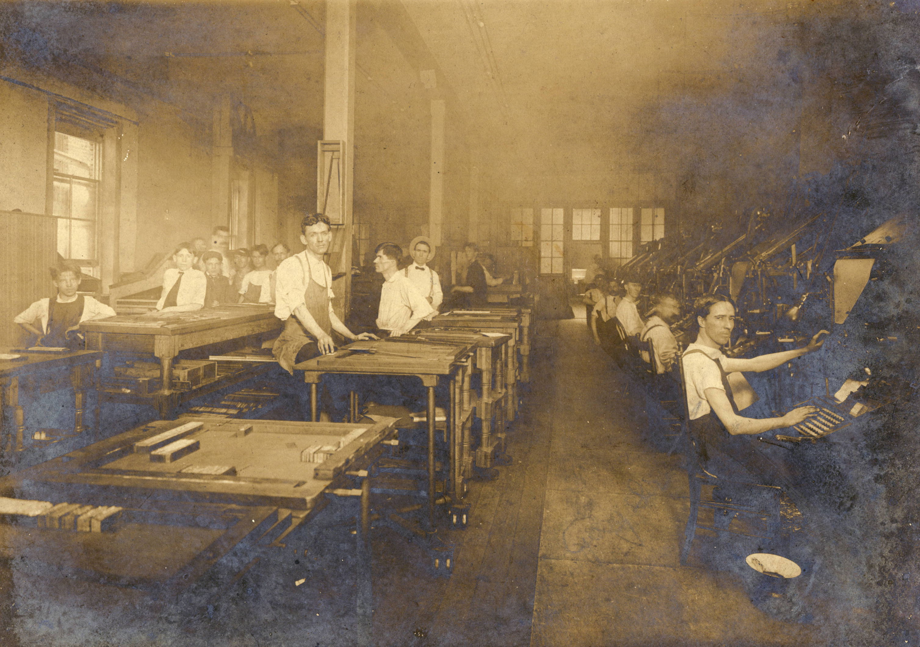 1906 composing room of the Atlanta Georgian depicting over a dozen men at various work stations