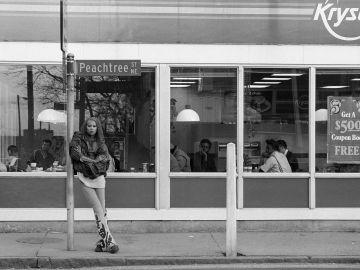 A young RuPaul leans against a Peachtree Street sign outside of a Krystal restaurant in Atlanta in 1988.